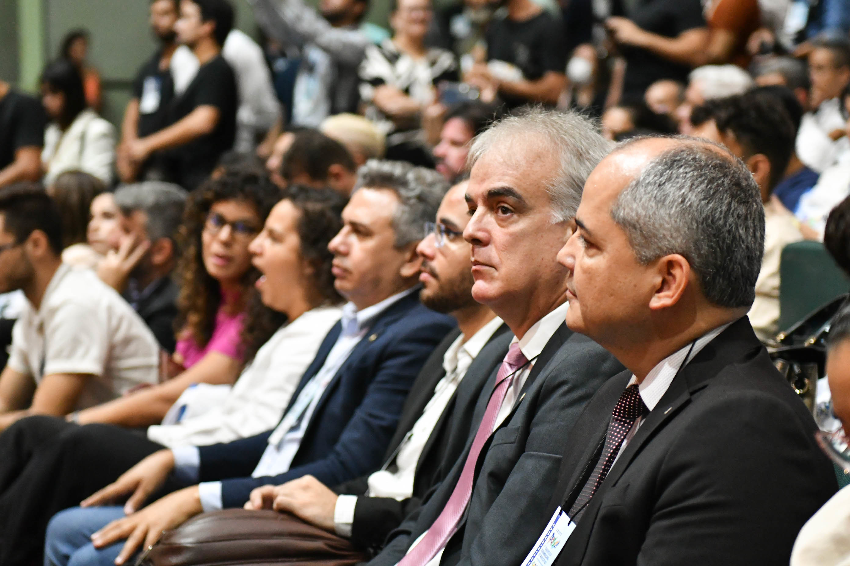 Fotografia do PGJ sentado em meio aos participantes do Congresso
