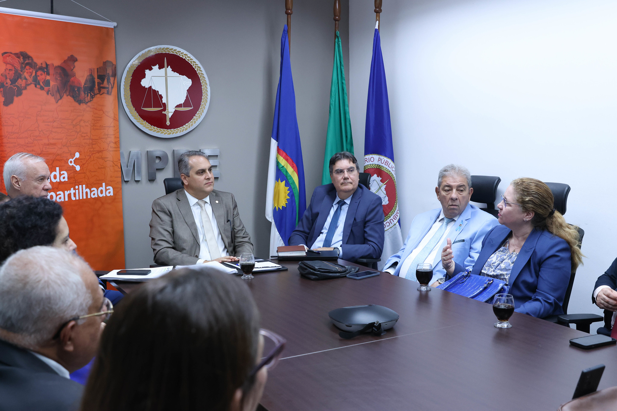 Fotografia de participantes da reunião sentados à mesa debatendo