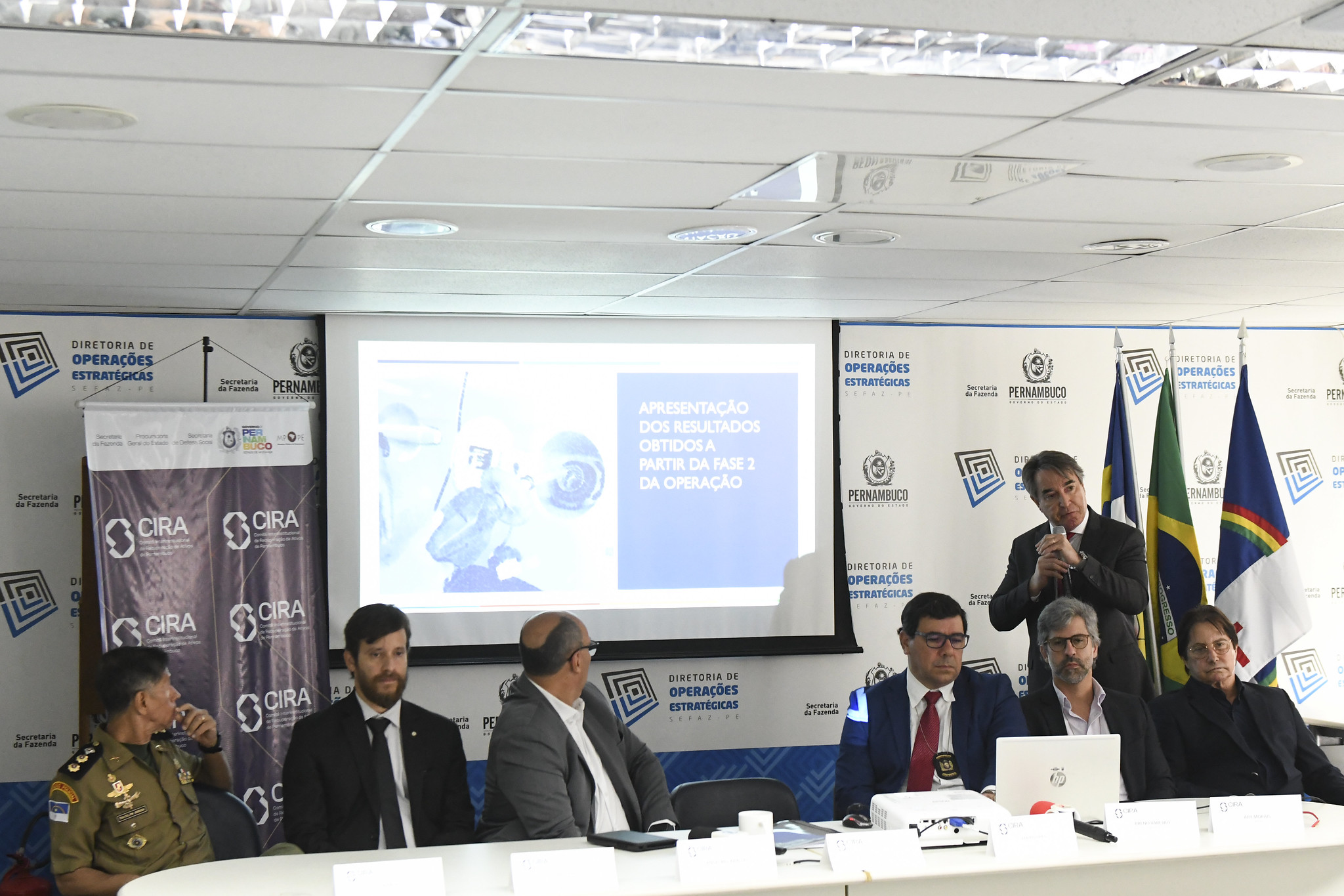 Fotografia de expositores e plateia da entrevista coletiva