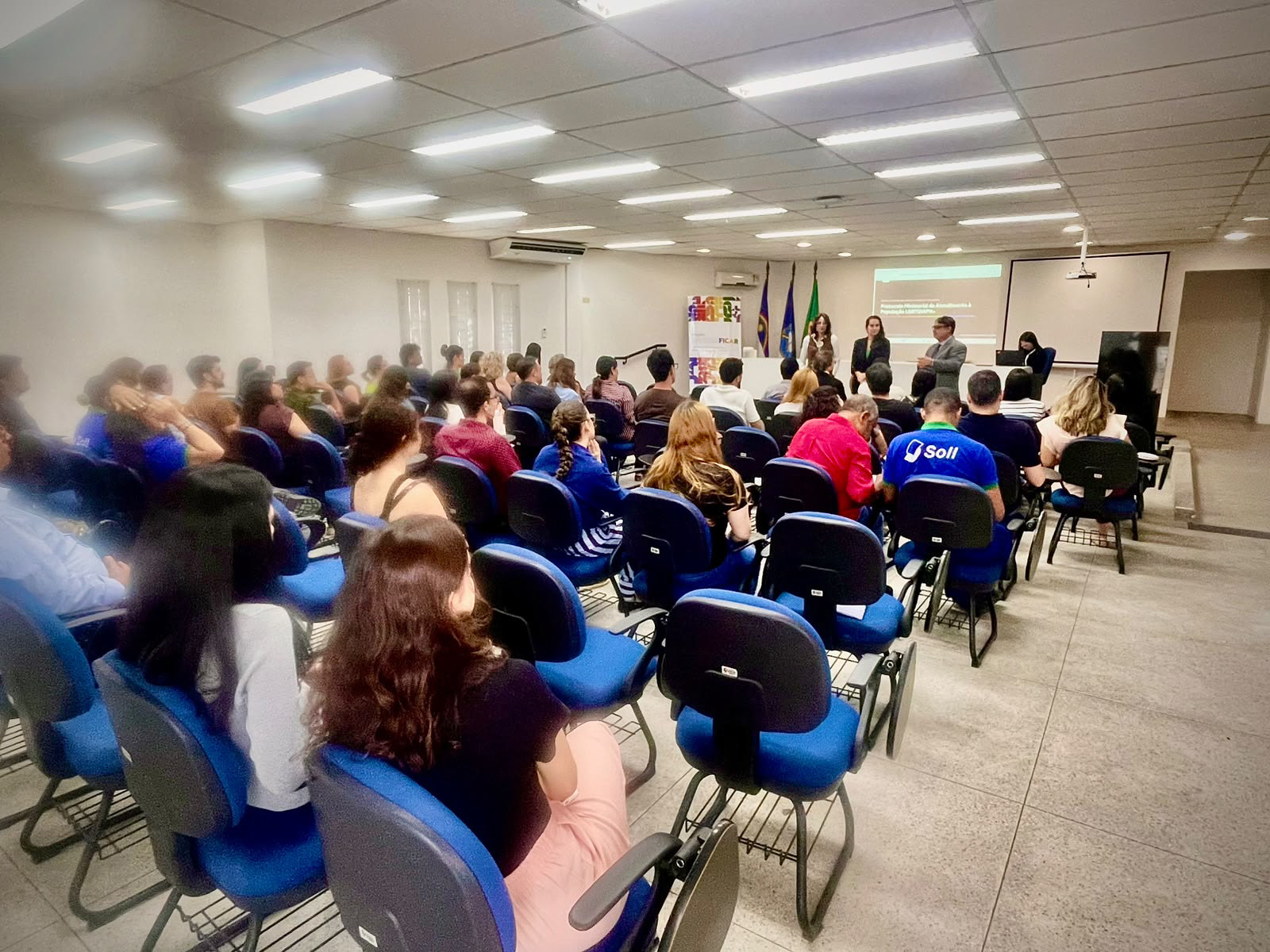 Fotografia de sala mostrando auditório repleto de pessoas