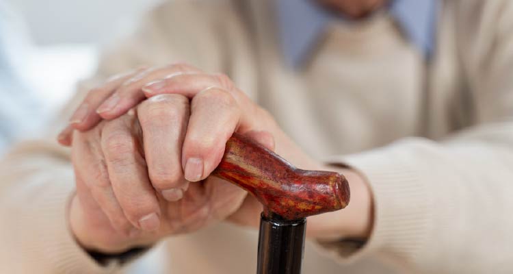 Fotografia de homem idoso segurando bengala