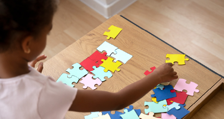 Fotografia de criança brincando com quebra-cabeça colorido