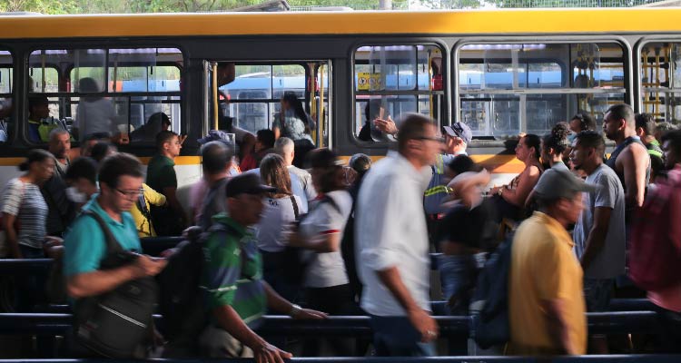 Imagem de pessoas em terminal em fila para subir no ônibus