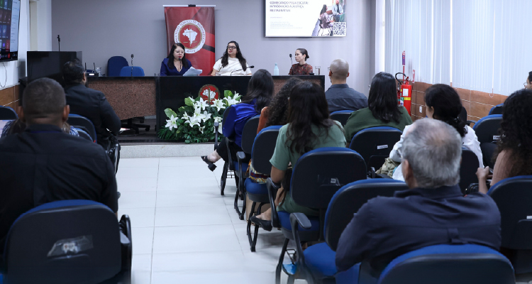 Fotografia da plateia observando mesa de apresentação