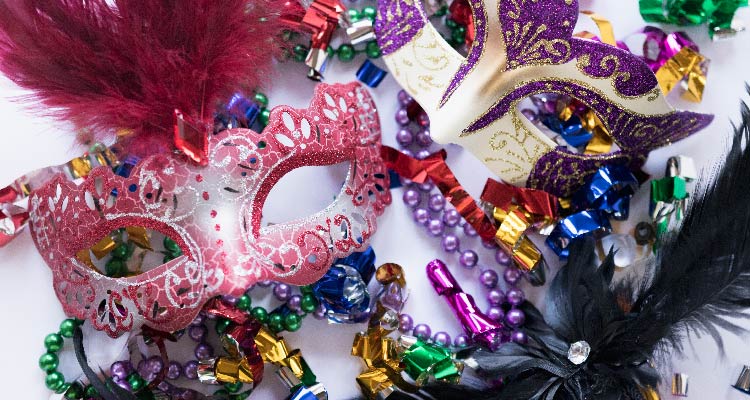 Fotografia de máscaras de carnaval junto a confetes e serpentinas