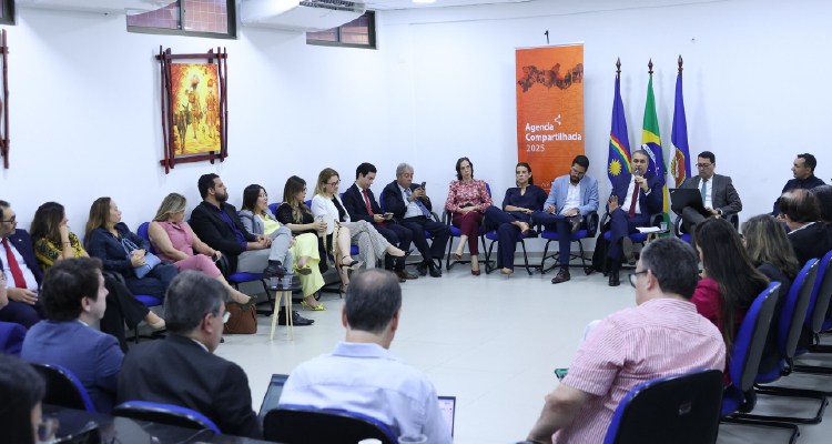 Fotografia de participantes do evento sentados em círculo para a reunião