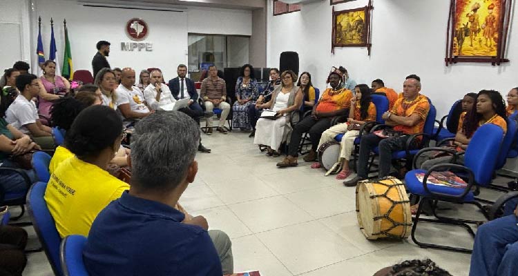 Fotografia dos participantes da reunião sentados em círculo discutindo