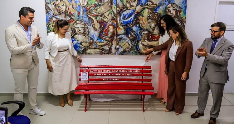 Fotografia de participantes do evento em volta do banco vermelho