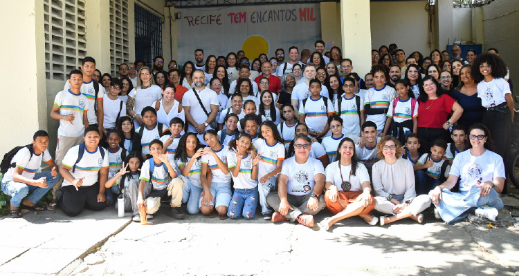 Fotografia de todos os estudantes, professores e promotores em frente à escola