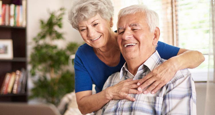 Fotografia de casal de idosos sorrindo juntos