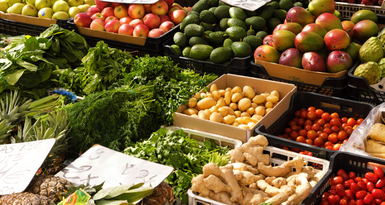 Fotografia de verduras e frutas expostas em banca de mercado
