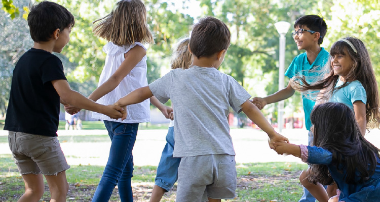 Imagem de crianças brincando de roda em parque
