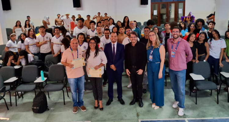 Fotografia de participantes do evento na plateia posando para foto