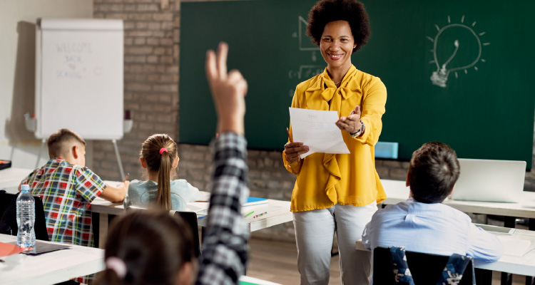 Imagem de professora dando aula diante de alunos