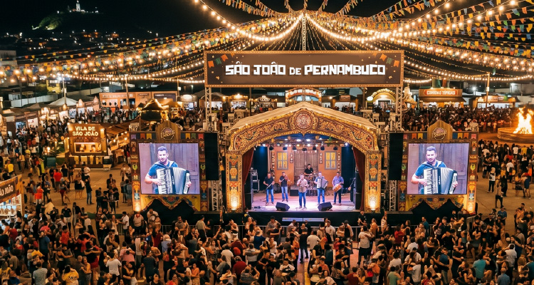 Imagem de palco de shows cercado por multidão