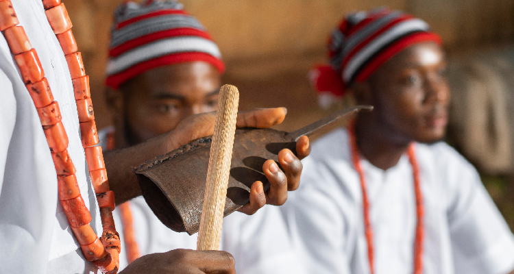 Fotografia de homens negros vestidos de branco e com adereços e instrumentos musicais de religiões de matriz africana