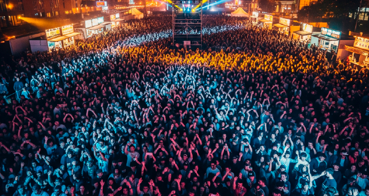 Fotografia de multidão diante de palco curtindo show