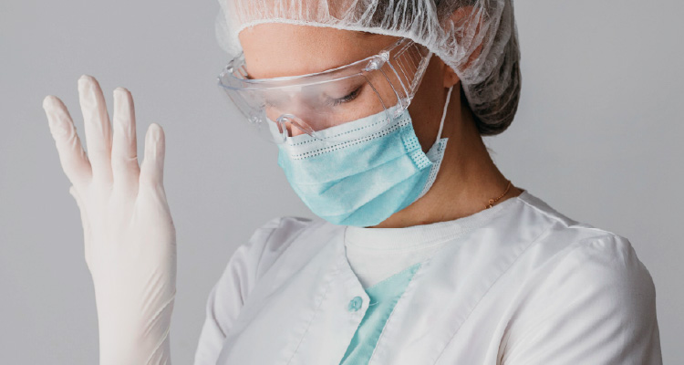 Fotografia de mulher vestindo luva e usando equipamentos de proteção individual