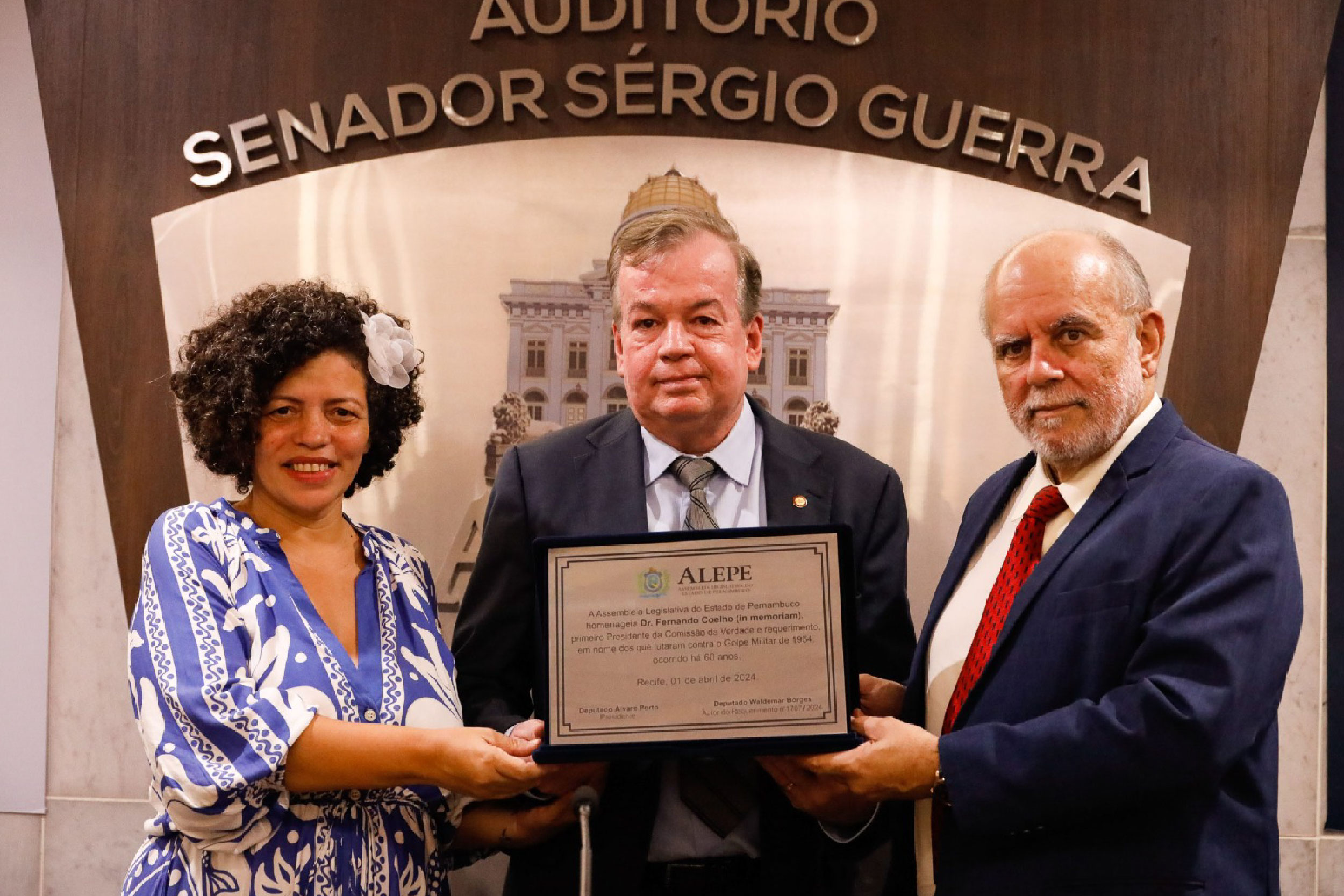 Fotografia do Procurador de Justiça Ricardo Coelho recebendo diploma com nome do pai