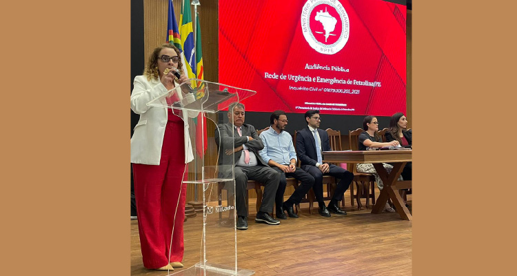 Fotografia de Promotora de Justiça discursando para plateia