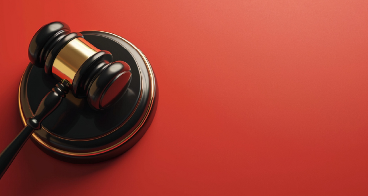 Fotografia de martelinho de juiz sobre fundo vermelho
