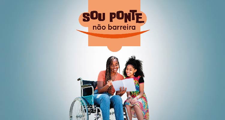 Em uma imagem retangular em fundo cinza, aparece no canto superior central da peça uma ilustração que faz referência a uma peça de quebra-cabeça de fundo laranja, dentro dela a seguinte informação: sou ponte, não barreira. Abaixo, aparece a imagem de duas meninas negras lendo um livro e sorrindo, uma delas é cadeirante e veste uma calça jeans e uma blusa laranja, a outra está de vestido colorido na altura dos joelhos.