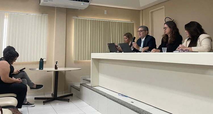 Fotografia de participantes do evento sentados na frente ao auditório