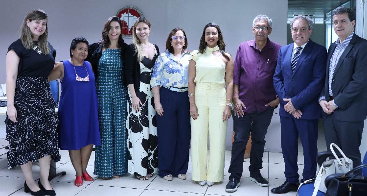 Fotografia de participantes da reunião posando em pé lado a lado