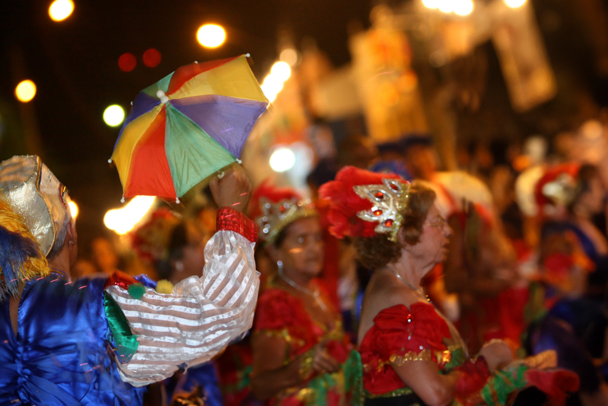 Fotografia de pessoas brincando carnaval na rua fantasiadas