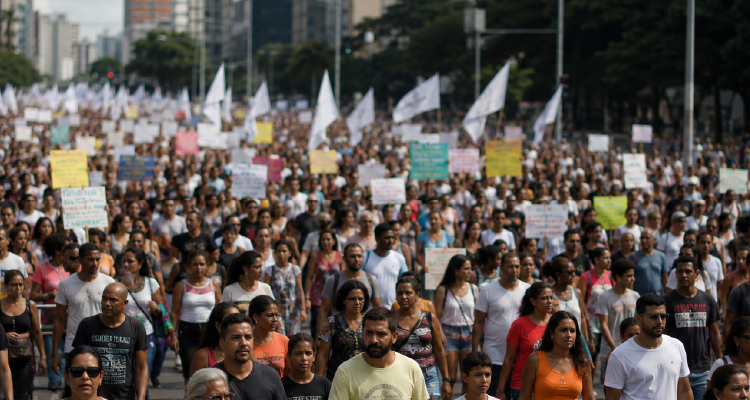 Imagem de pessoas se manifestando com bandeiras e cartazes 