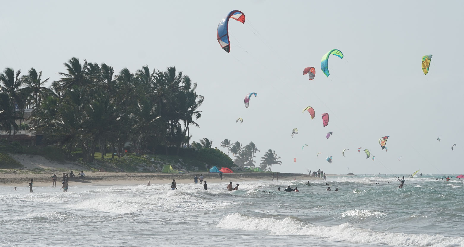 Fotografia de praia com pessoas praticando esportes náuticos