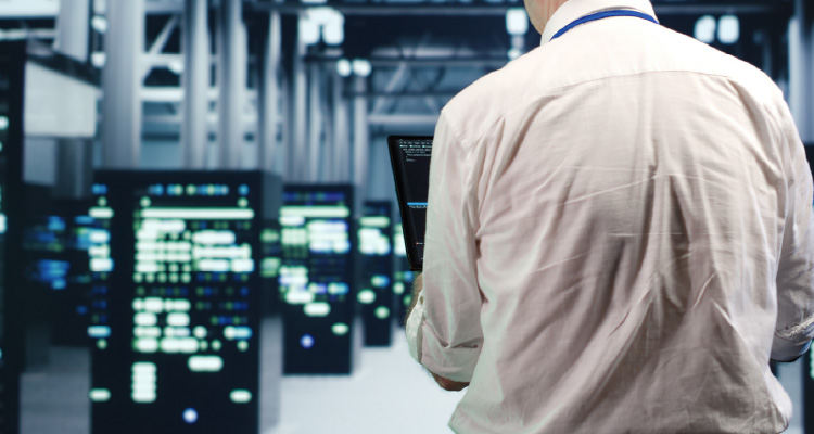Imagem de pessoa percorrendo corredor com servidores de data center