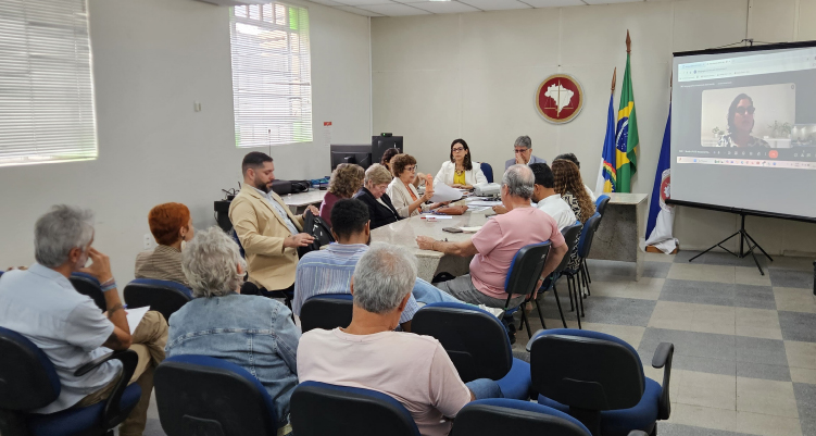 Foto dos participantes da reunião sentados à mesa discutindo
