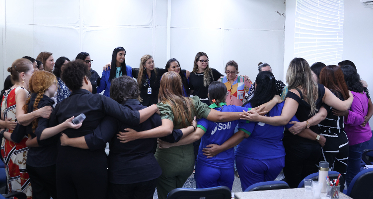 Fotografia de participantes abraçadas em roda