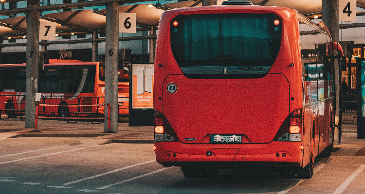 Fotografia de traseira de ônibus vermelho estacionado em garagem