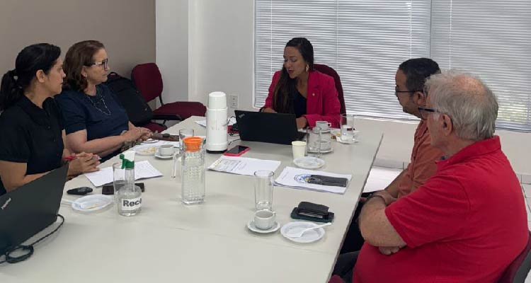 Fotografia de pessoas reunidas em volta de mesa
