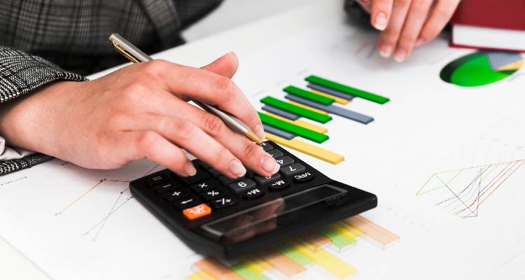 Foto de mão digitando em calculadora