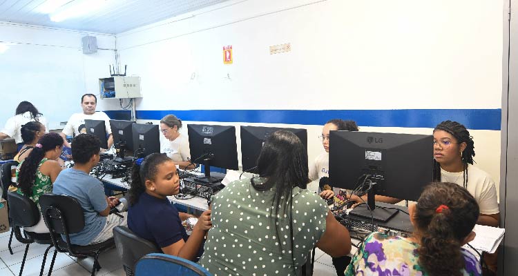 Fotografia de pessoas em bancada com computadores