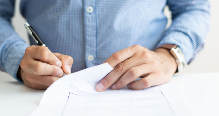 Fotografia de homem assinando papéis