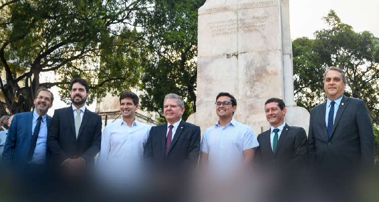 Fotografia dos participantes da inauguração junto a uma estátua 