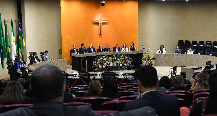 Fotografia de plateia diante de mesa de autoridades