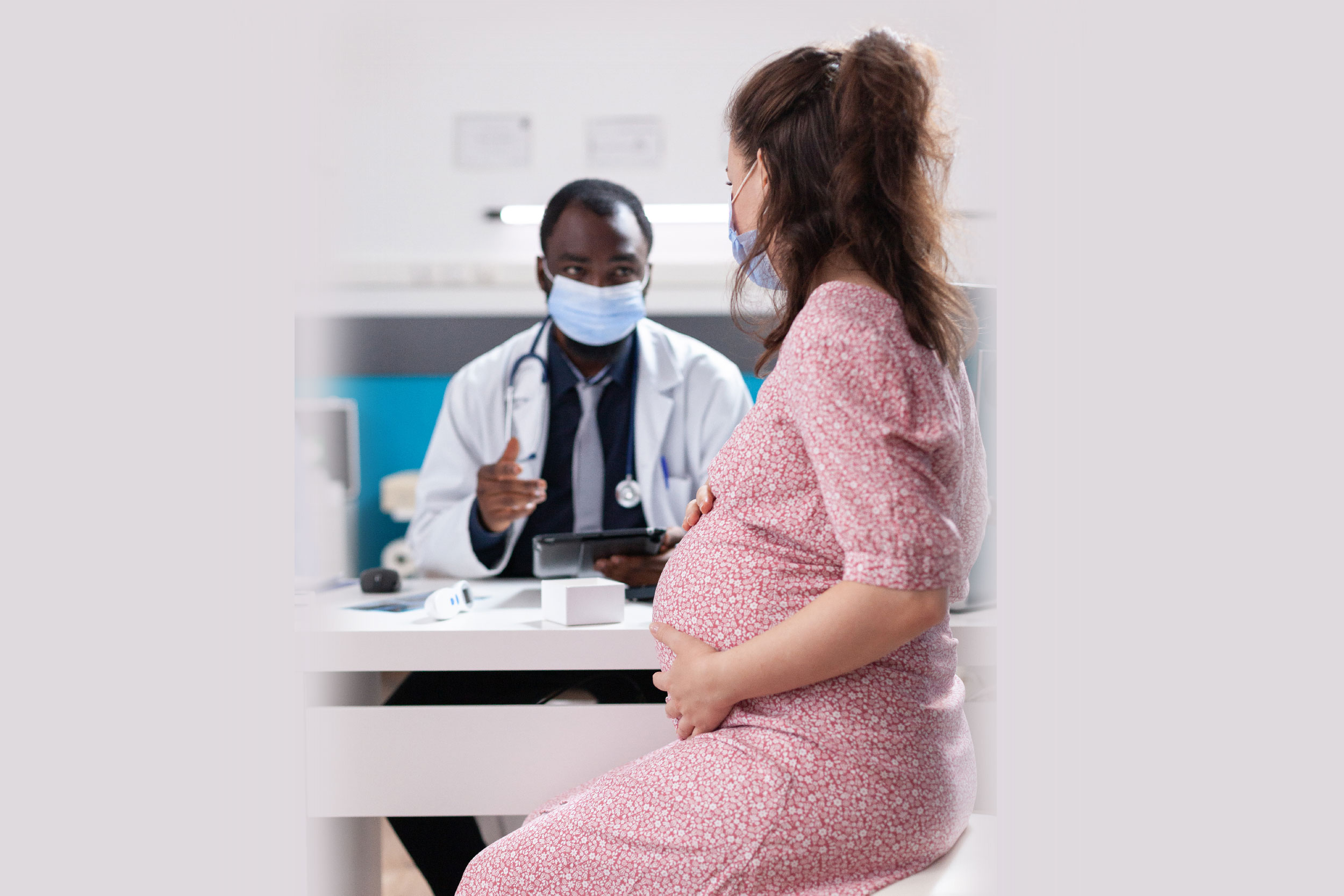 Fotografia de mulher grávida se consultando com médico