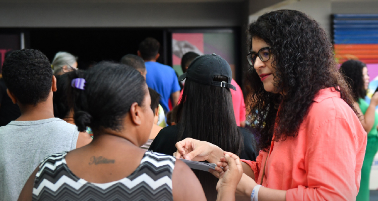 Fotografia da PJ Maísa Oliveira conversando com uma participante do evento