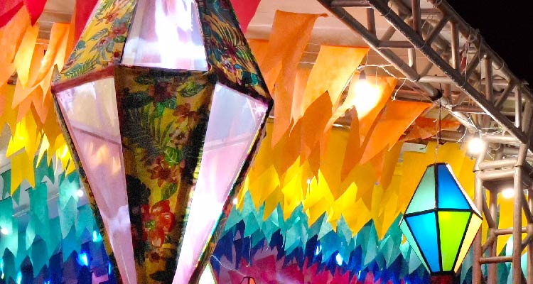 Balão e bandeirolas decorativas de São João penduradas no teto de um galpão