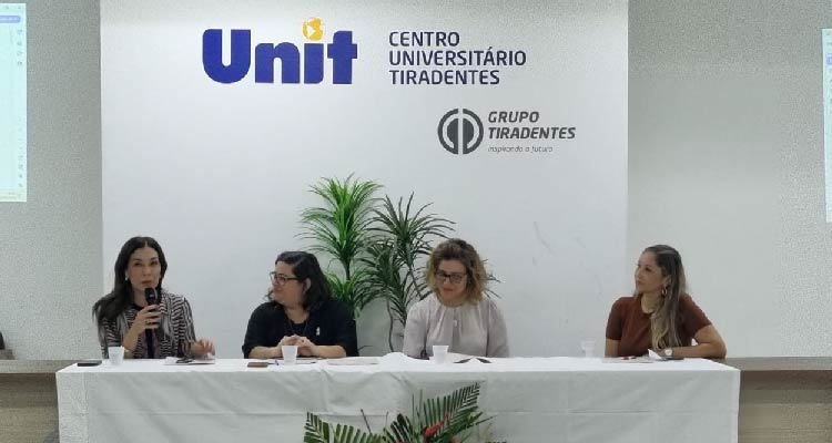 Fotografia das participantes em mesa principal