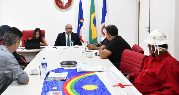 Fotografia de participantes da reunião debatendo em volta da mesa