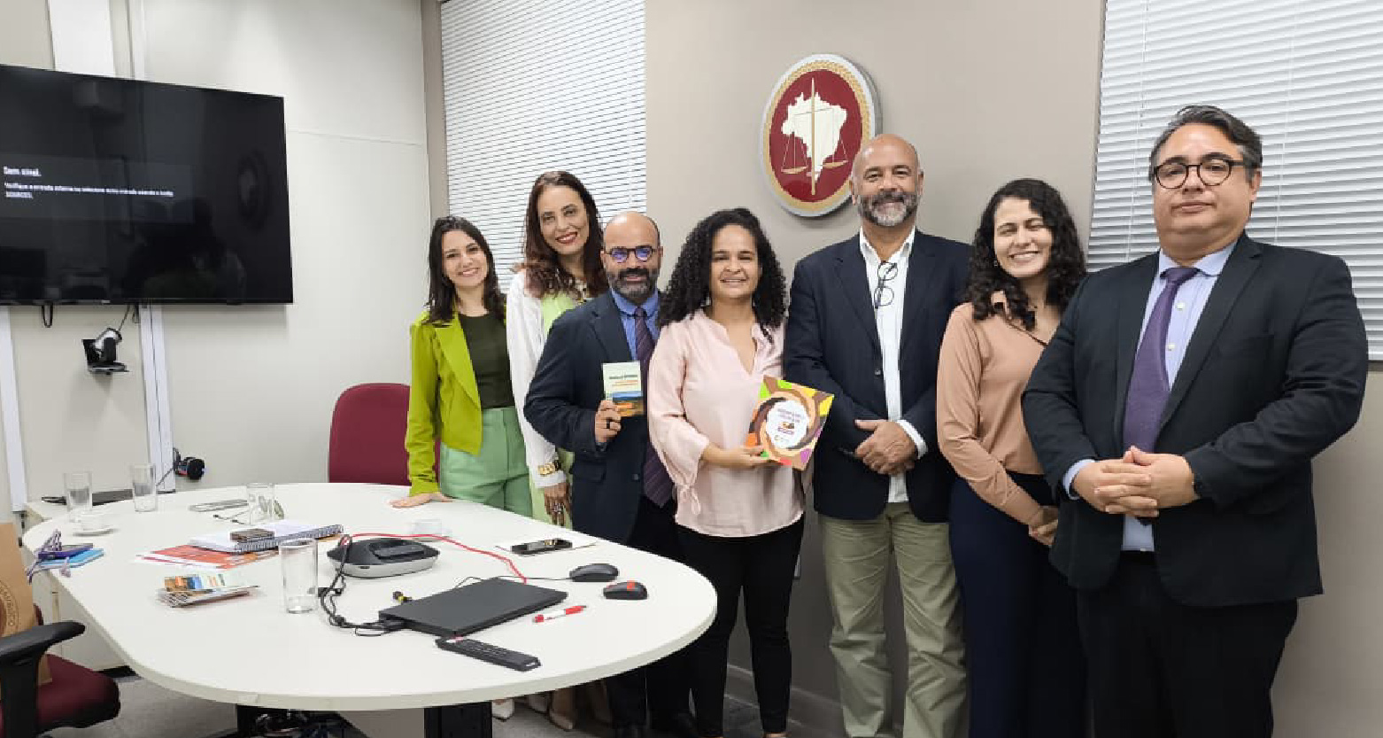 Fotografia de participantes da reunião posando em pé para a câmera