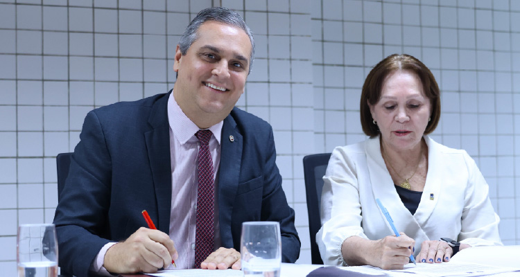 Fotografia do PGJ e da reitora assinando contrato
