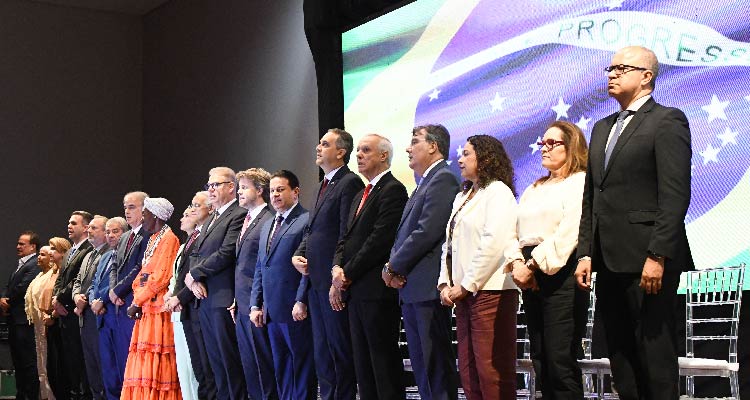 Fotografia de homenageados em pé sobre o palco