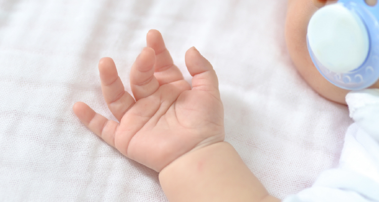 Fotografia parcial de bebê em berço